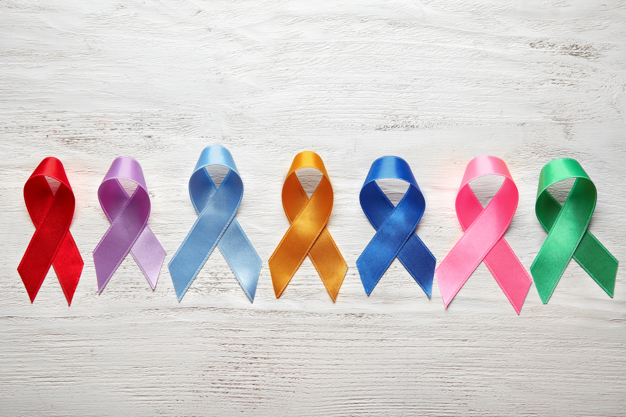 Different colorful ribbons on white wooden background. Cancer concept Different colorful ribbons on white wooden background. Cancer concept