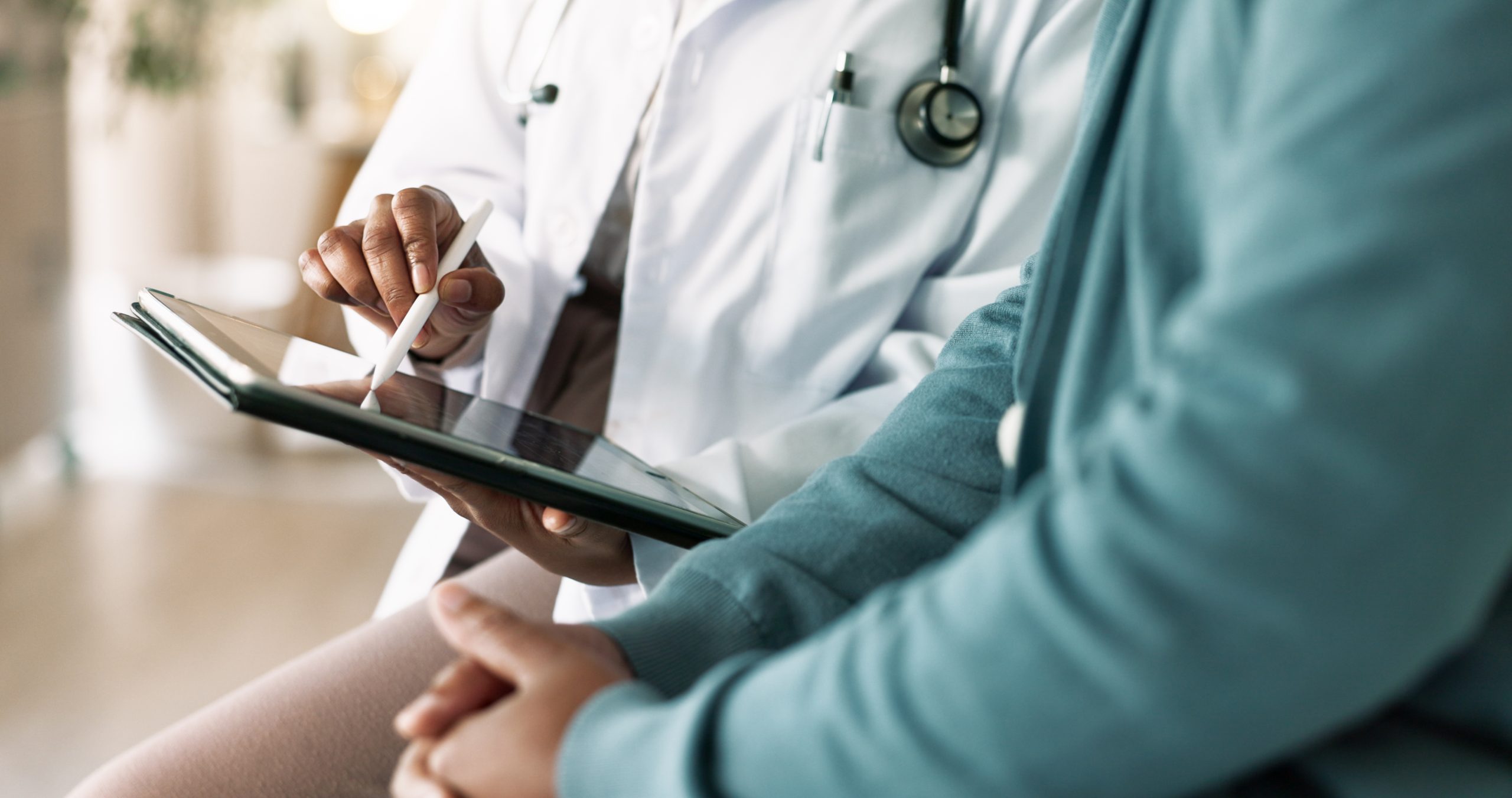 Doctor, hands and tablet with patient for consultation, medical advice or procedure at clinic. Closeup, healthcare employee and client with technology for health appointment or checklist at hospital